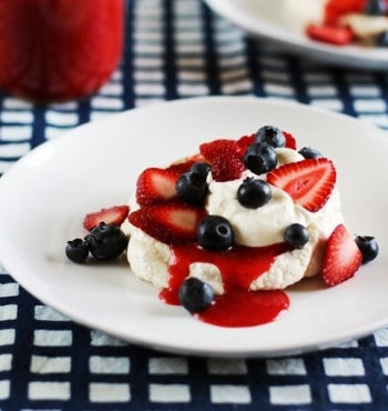 Cute mini berry pavlovas with strawberry sauce