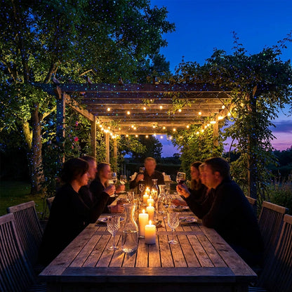 Outdoor dinner party with garden laser light projecting blue and green dots across pergola and trees