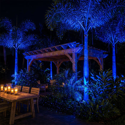 Outdoor pergola dining area with palms drenched in HighBright blue and green laser light