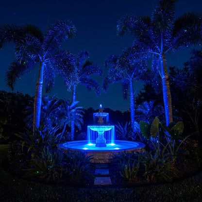 Premium garden with fountain centerpiece and palms lit by HighBright laser projector blue and green dots
