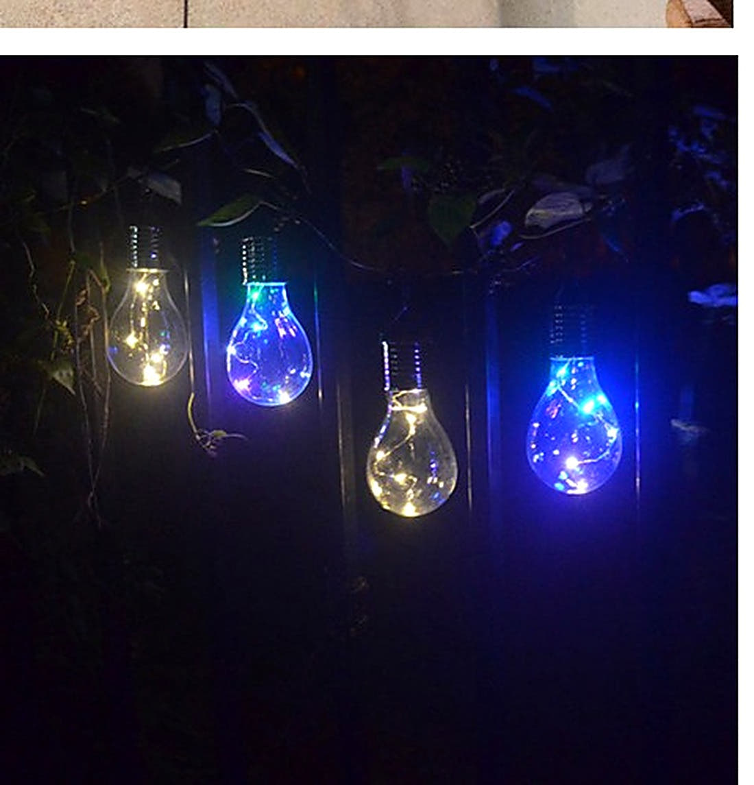 Solar hanging light bulbs glowing multicolour in a dark garden at night