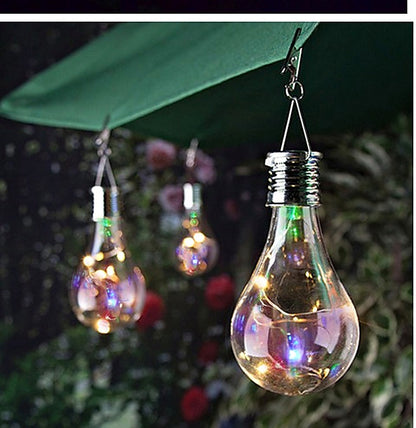 Solar tree light bulbs glowing in colour under a garden canopy at dusk